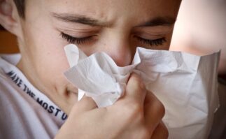 Boy blowing his nose in a tissue