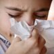 Boy blowing his nose in a tissue